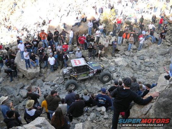 Off-road buggy with Monster Energy sponsorship navigating a rocky terrain