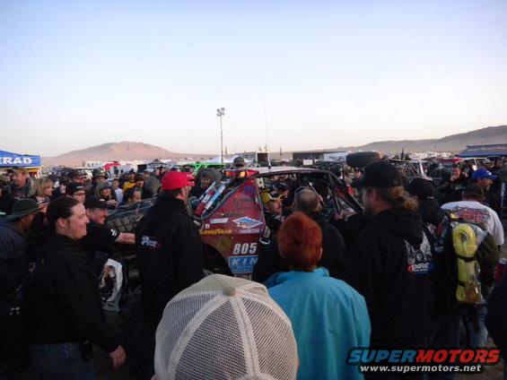 Off-road race truck with number 805, surrounded by a crowd