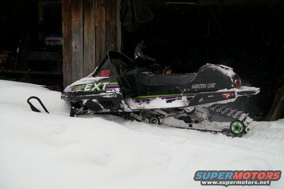 Arctic Cat snowmobile in snow, 'EXT' on front, 'ARCTIC CAT' on side