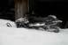 1990 Arctic Cat El Tigre EXT - Snowmobile parked in the snow next to a wooden structure.