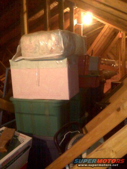 Attic storage with boxes and insulation under wooden beams
