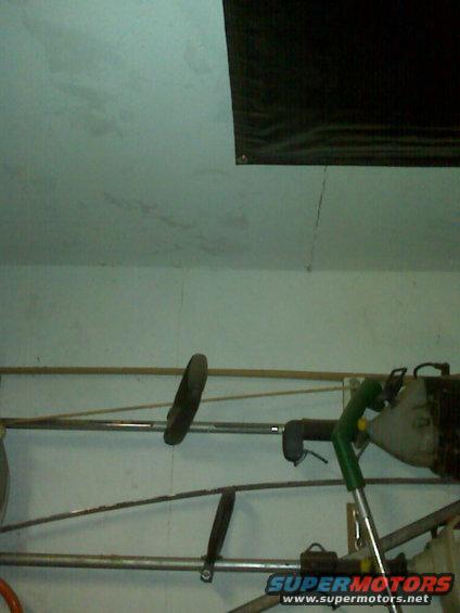 String trimmer and other tools hanging on a wall