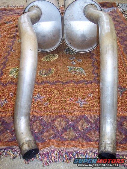Exhaust mufflers with curved pipes