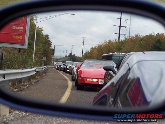 Line of C4 Corvettes in traffic, viewed from a side mirror