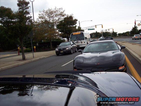 Black Chevrolet Corvette from the front-right, showing its distinctive headlights and hood emblem
