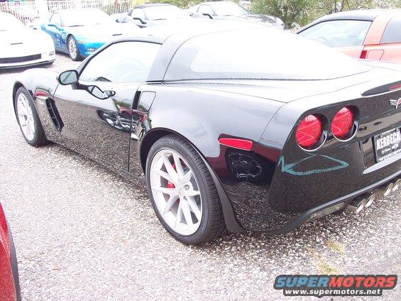Black Chevrolet Corvette rear quarter with quad exhaust pipes and red taillights