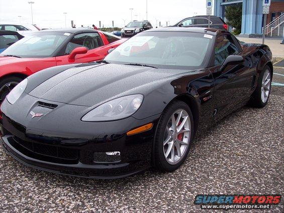 Black Corvette parked next to a red one. Looks like a 2006 Chevrolet Corvette
