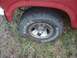 1985 Ford Bronco - Wheel and tire detail of a red vehicle, showing 'Sidewinder' radial tire text.