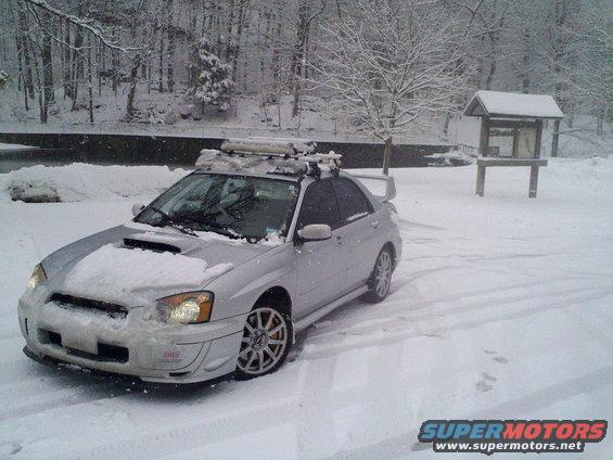 Silver 2004 Subaru Impreza WRX STI with roof rack, covered in snow