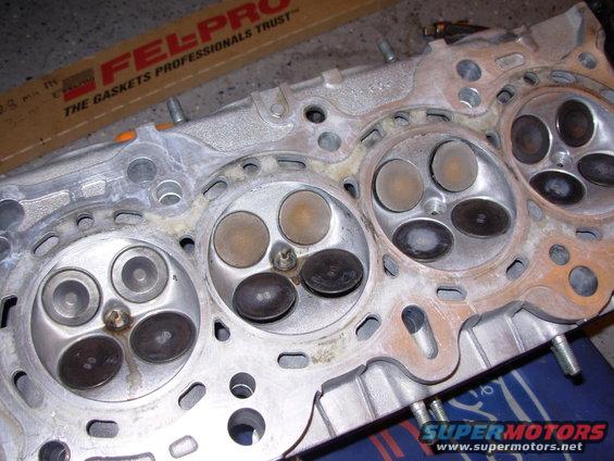 Engine cylinder head with valves visible. Box of Fel-Pro gaskets in background