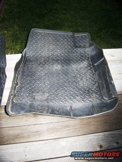 Black rubber floor mat with diamond tread pattern and raised edges