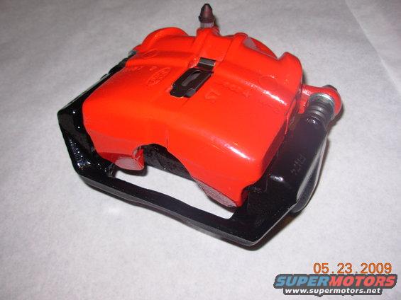 Red brake caliper with black bracket, viewed from a 3/4 angle