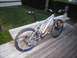 1986 Ford Bronco - A silver full-suspension mountain bike with blue rims rests on a wooden deck next to a bench.