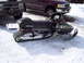 1990 Arctic Cat El Tigre EXT - A 1990 Arctic Cat El Tigre EXT snowmobile is parked in the snow next to two trucks.