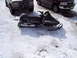 1990 Arctic Cat El Tigre EXT - A 1990 Arctic Cat El Tigre EXT snowmobile sits in a snowy lot next to two trucks.