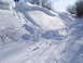 1990 Arctic Cat El Tigre EXT - Tracks mark a path up a snow-covered hill on a sunny day.