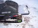 1990 Arctic Cat El Tigre EXT - The rear of an Arctic Cat snowmobile is shown in the snow, with a damaged seat and a metal rack.
