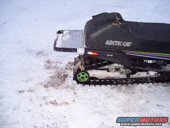 Arctic Cat snowmobile side view with green track wheels