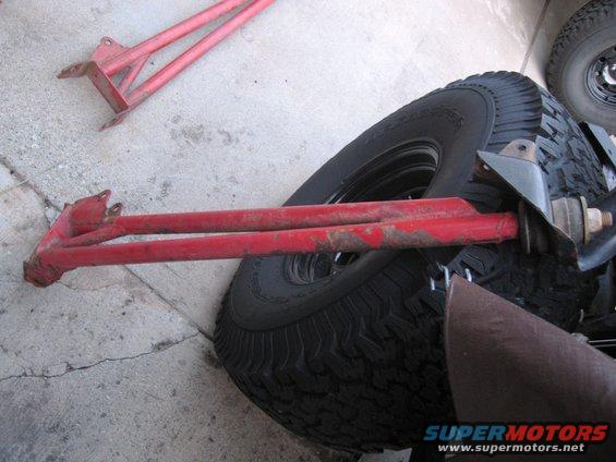 Red radius arms next to a tire