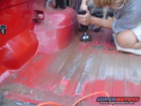 Red interior floor being prepped with a power tool
