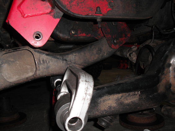 Close-up of suspension parts and driveshaft, likely under a vehicle