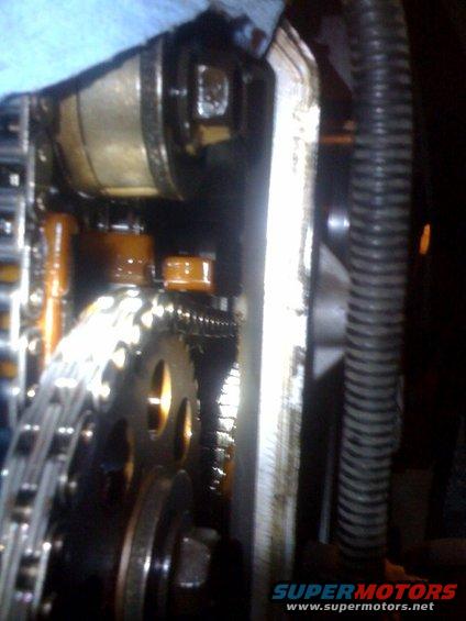 Close-up of engine timing chain and gears with oil