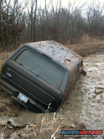 1996 Ford Bronco stuck in mud, rear 3/4 view