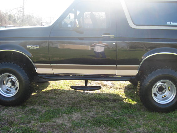 Dark brown and tan 1994 Ford Bronco side view with running boards and BFGoodrich tire