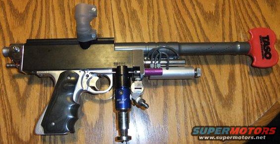 Paintball marker with black grip and red TASO handle