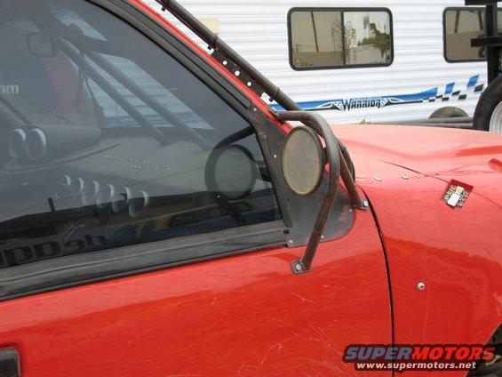 Red off-road vehicle with roll cage and large side mirror