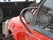 1986 Ford Bronco - Close-up of a red 1986 Ford Bronco fender and side mirror with a custom roll cage.