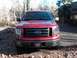 2009 Ford F-150 - The front grille of a red Ford F-150 truck is visible, with a license plate below.