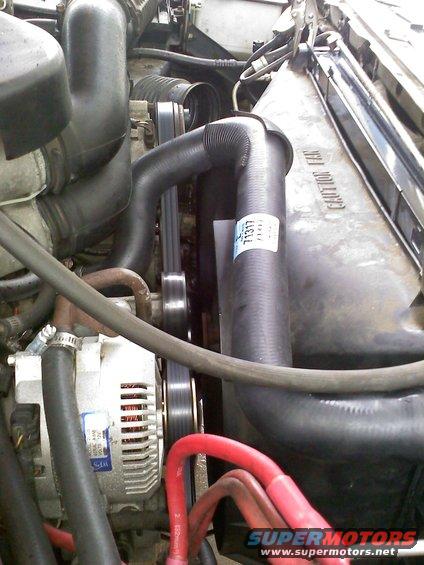 Engine bay detail showing alternator, belts, and radiator hoses. A sticker on a hose reads 71317