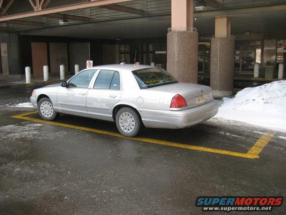 Silver sedan parked in a yellow-lined spot, text on door says 'TRAFFIC'. Looks like a police or government vehicle