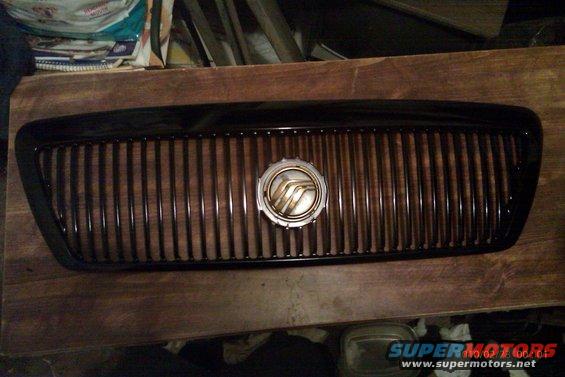 Mercury Grand Marquis grille with vertical slats and a circular emblem in the center