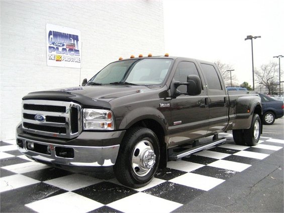 Dark brown dually pickup truck parked on checkered floor