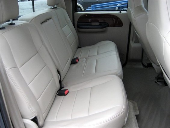 Interior rear seats with beige leather upholstery and seatbelts