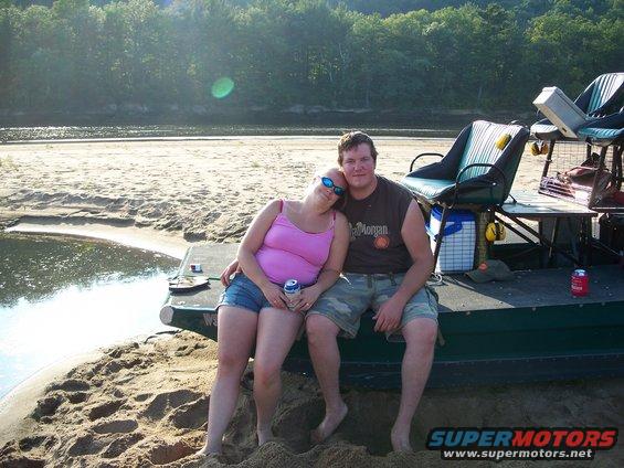 Couple sitting on a boat dock by a river