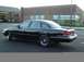 1996 Ford Crown Victoria - A black sedan is parked in a lot with a brick building in the background.