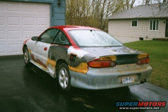 Car with primer and different paint colors, parked in driveway. License plate GZN 451
