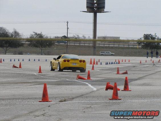 Yellow sports car on a race track with orange cones