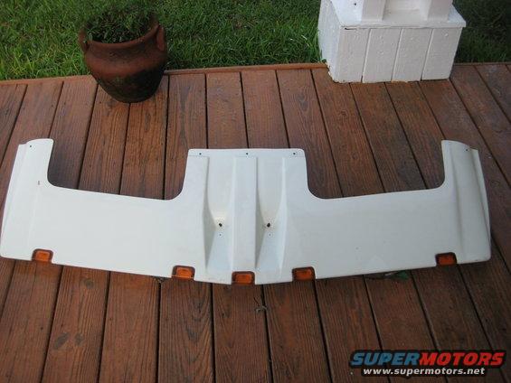 White plastic sun visor with amber marker lights, mounted on wooden deck