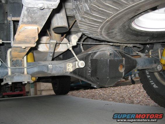 Underside view of a vehicle's rear axle, leaf springs, and exhaust pipe