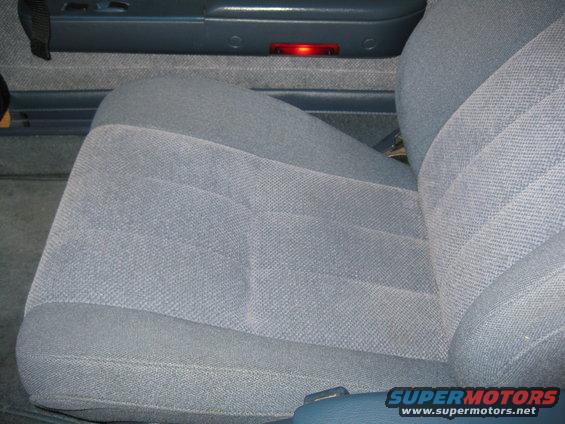Close-up of a blue fabric car seat and door panel with a red light