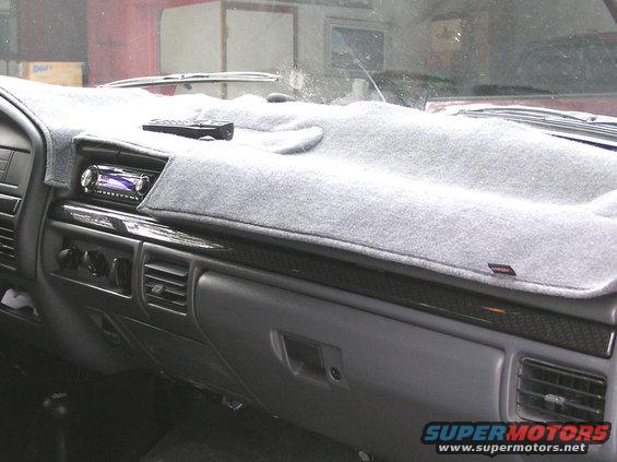 Gray dashboard with a gray dash cover, aftermarket stereo, and remote control