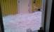 1989 Ford Bronco - A thick layer of snow covers the ground outside a building with a yellow facade and a white door.