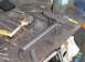 1993 Ford Bronco - Metal bracket assembly on a workbench with tools, likely for a vehicle repair or modification.