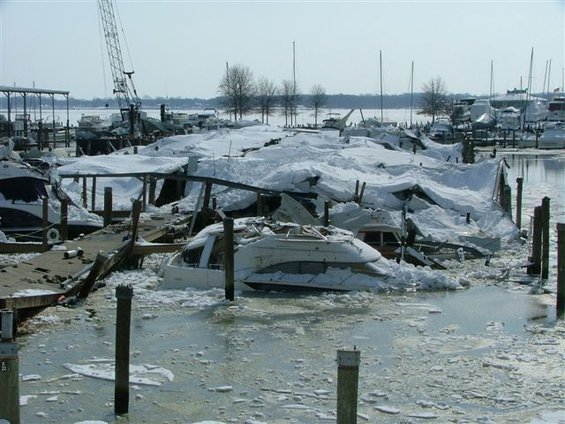 Boats damaged by snow and ice in a frozen marina