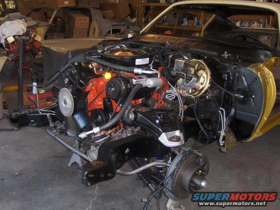 1971 Chevrolet Camaro engine bay and front suspension with engine removed, car is on jack stands