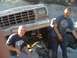 1976 Ford F-250 - Two men pose with a muddy Ford F-Series truck on a rocky terrain.